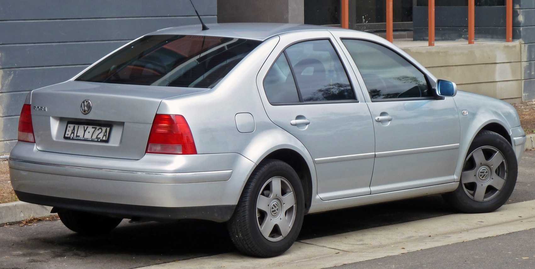 Rear side of silver sedan with five-spoke alloy wheels and tinted windows