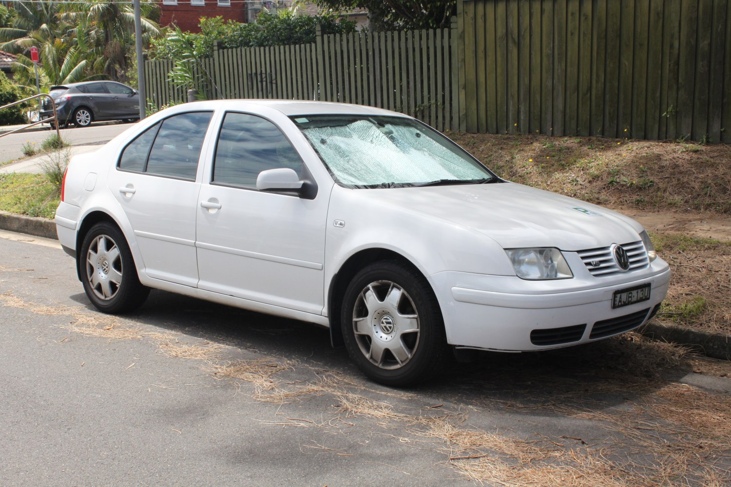 Front side view of white sedan with alloy wheels