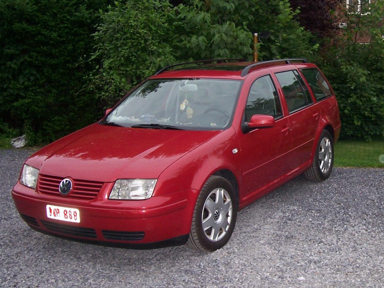 Red station wagon with roof rails and alloy wheels