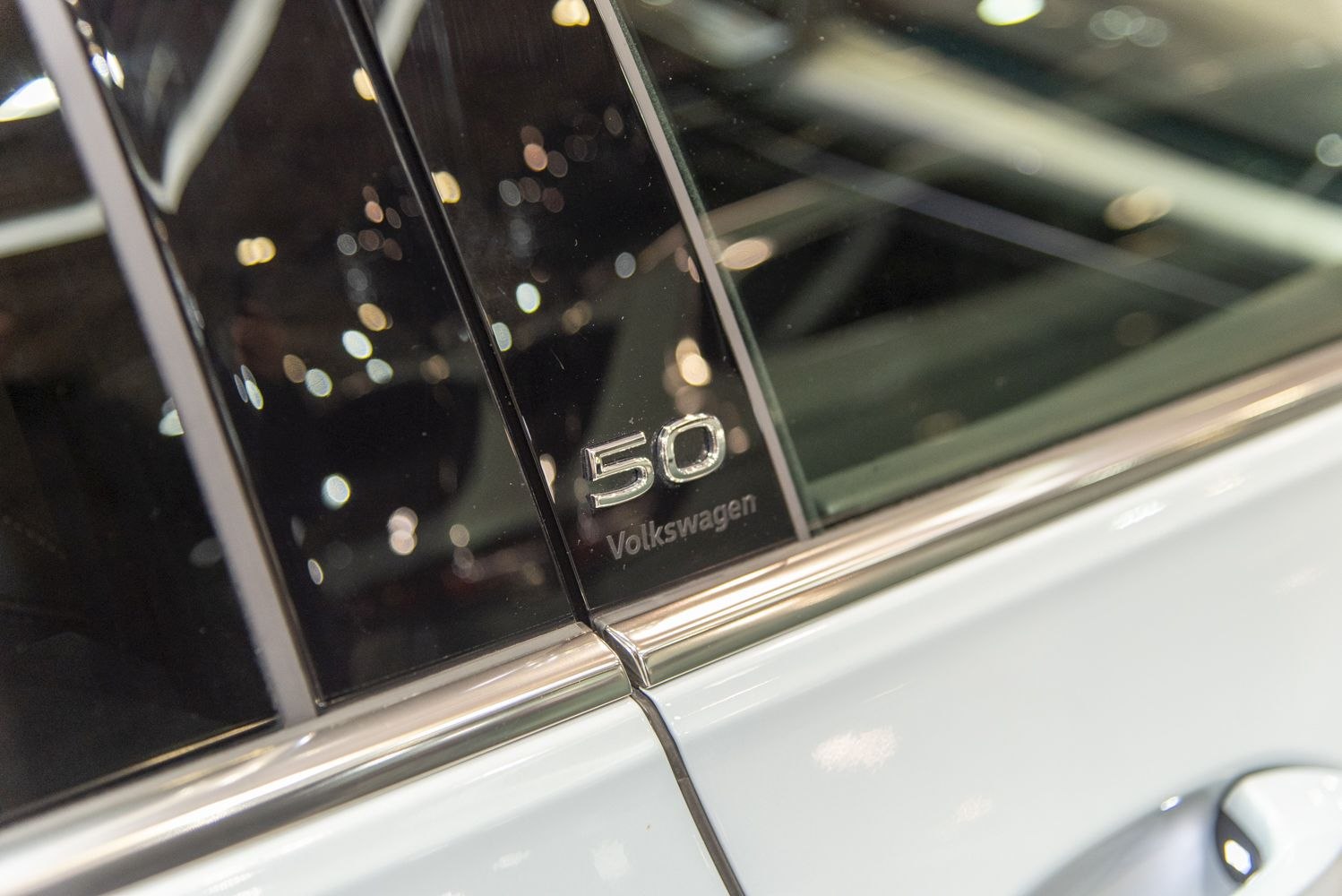 Close-up of Volkswagen 50th Anniversary badge on window pillar
