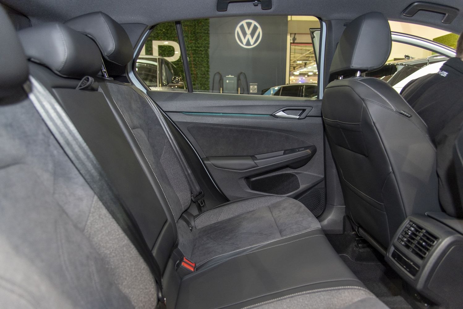 Rear interior seating and door panel with mixed upholstery and air vents