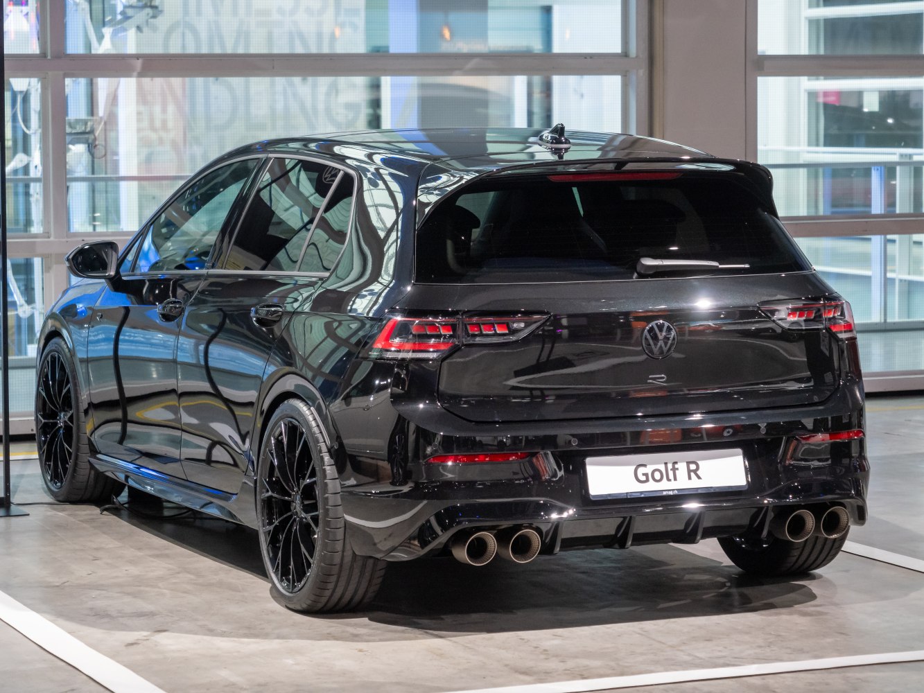 Sporty hatchback rear view with quad exhaust and black wheels