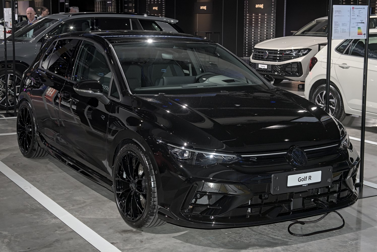 Black sporty hatchback with aggressive front design and large alloy wheels