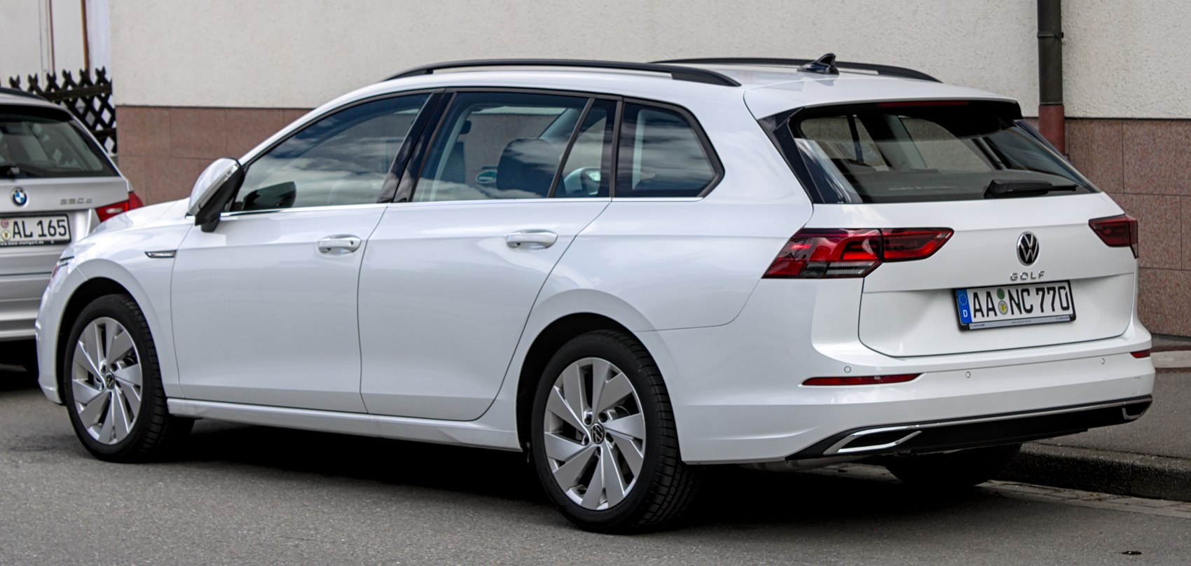 Rear and side view of a white station wagon with roof rails and modern tail lights
