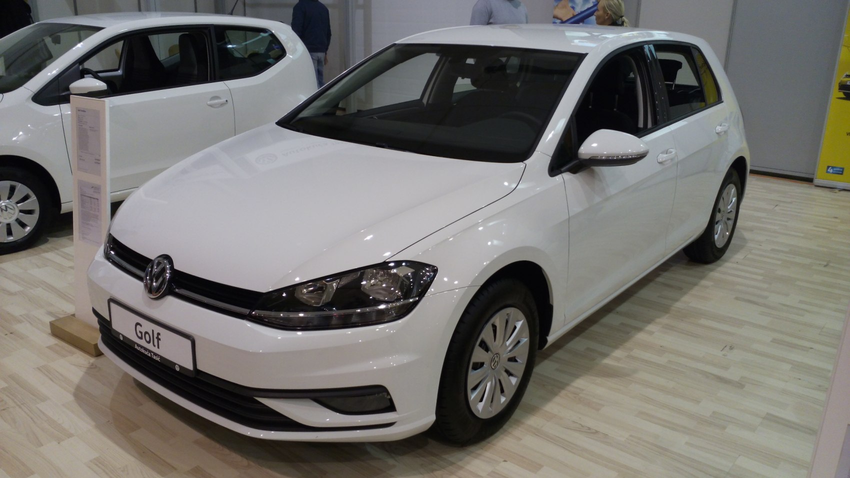 White hatchback front and side view with sleek headlights and smooth lines