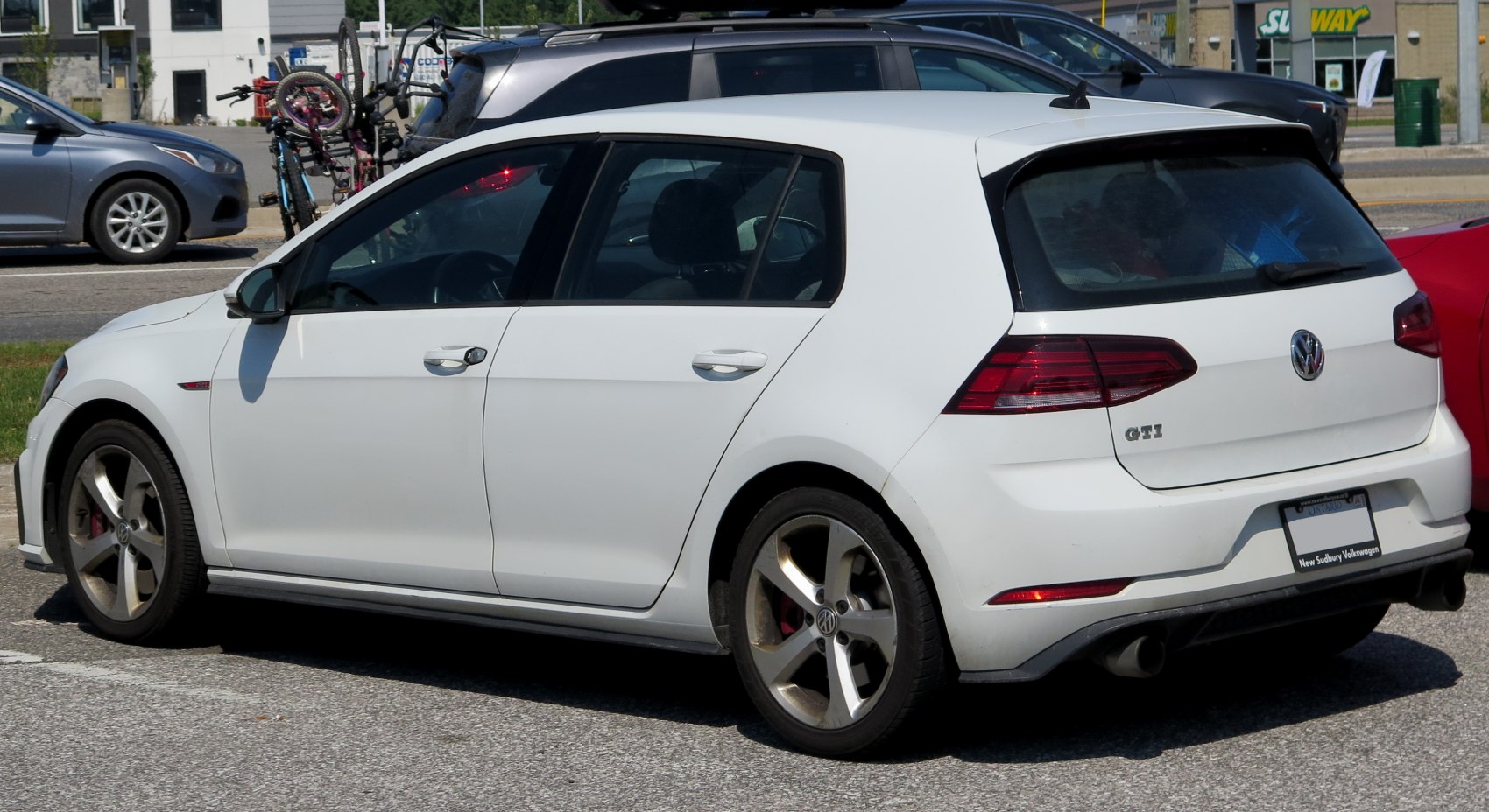White 5-door hatchback rear side profile with dual exhaust