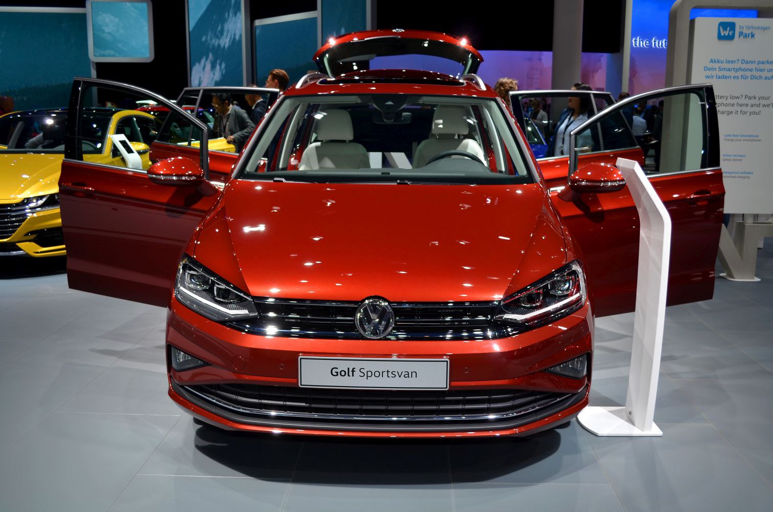 Front view of a red car with all doors open and modern headlights
