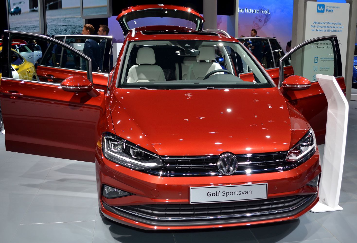Front view with open front doors and rear hatch of red hatchback