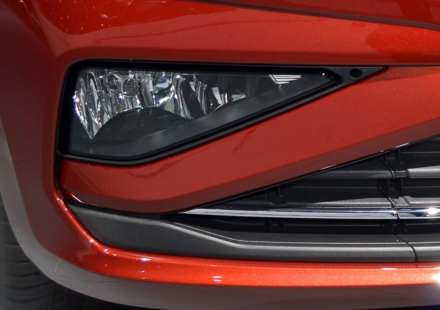 Close-up of front fog light and grille on red car