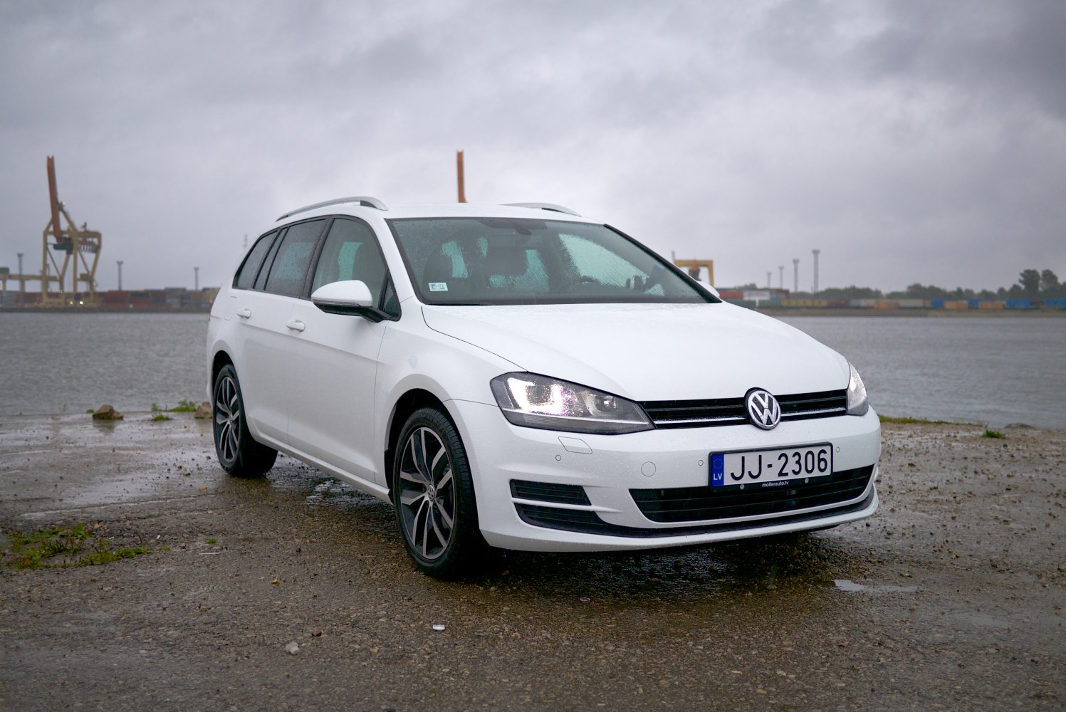 White station wagon with LED headlights and alloy wheels on wet surface