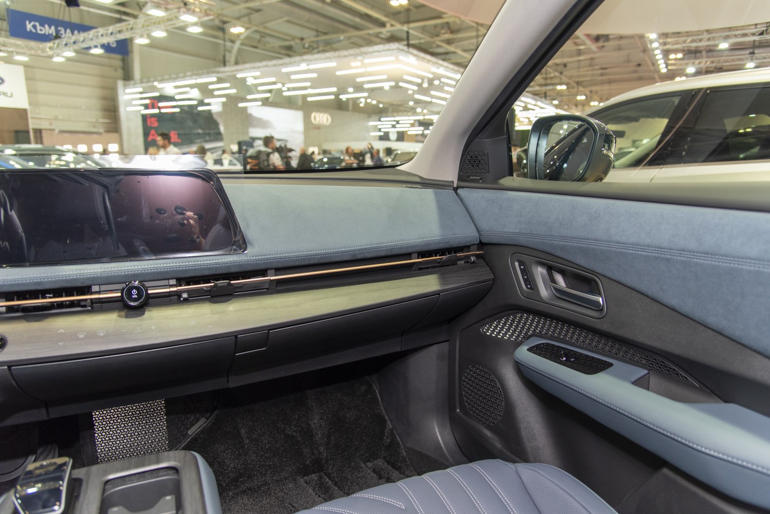 Modern car interior dashboard and passenger side with infotainment screen and detailed door panel.