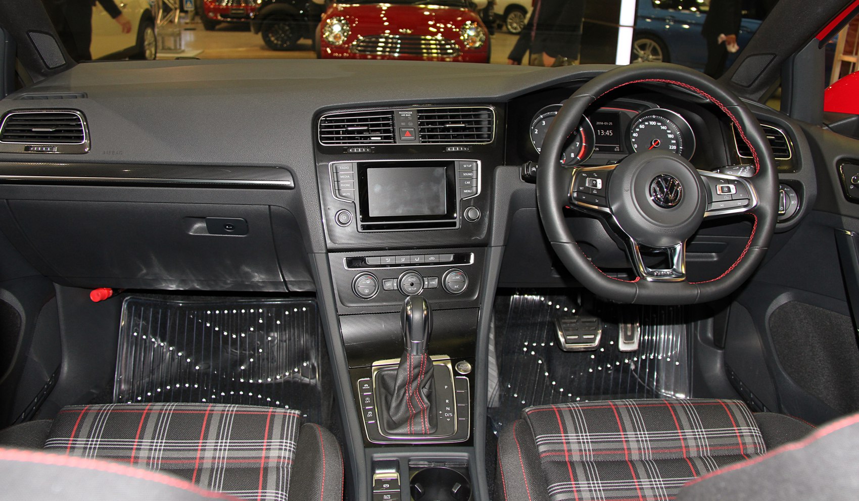 Interior view with dashboard, steering wheel, gear shift and plaid seats