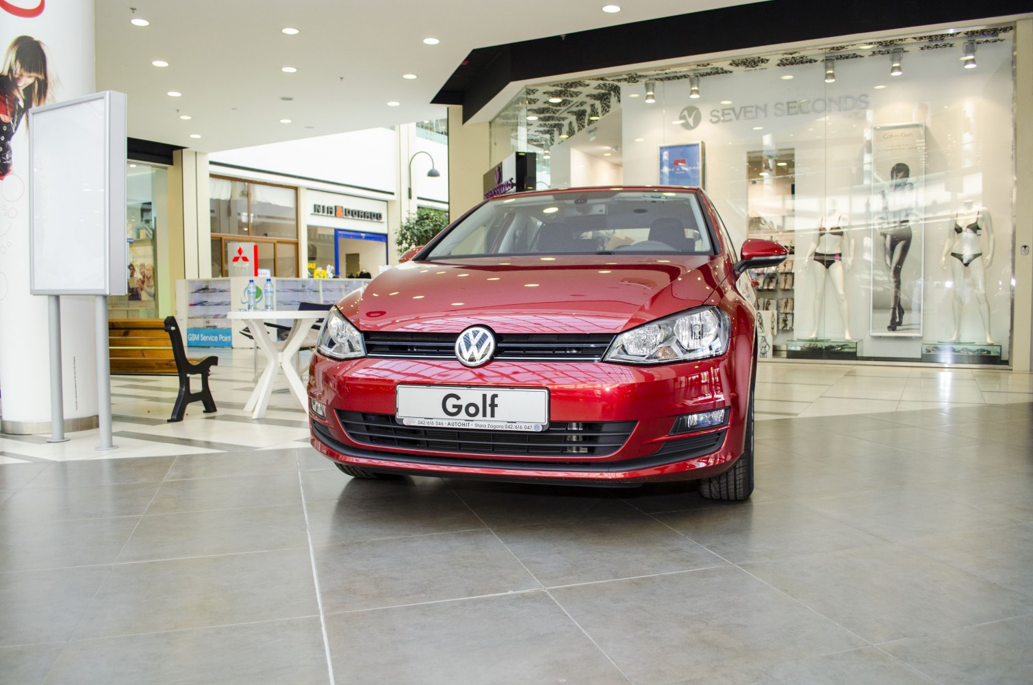 Red hatchback front view with detailed headlights and grille