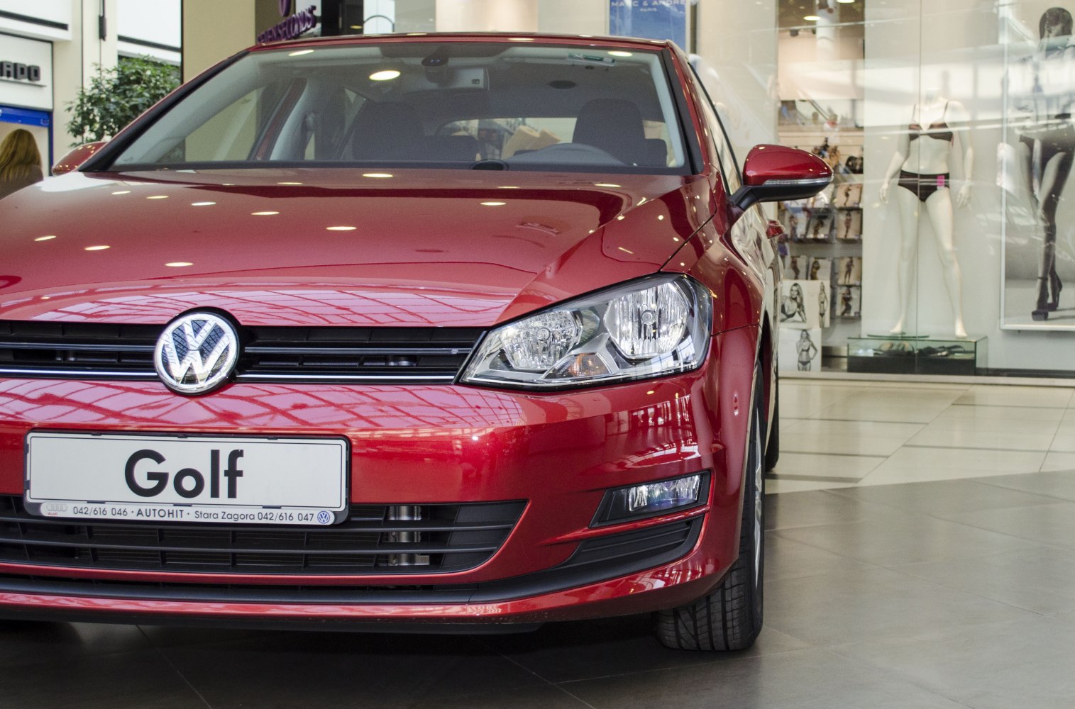 Front view with headlights and grille of red hatchback