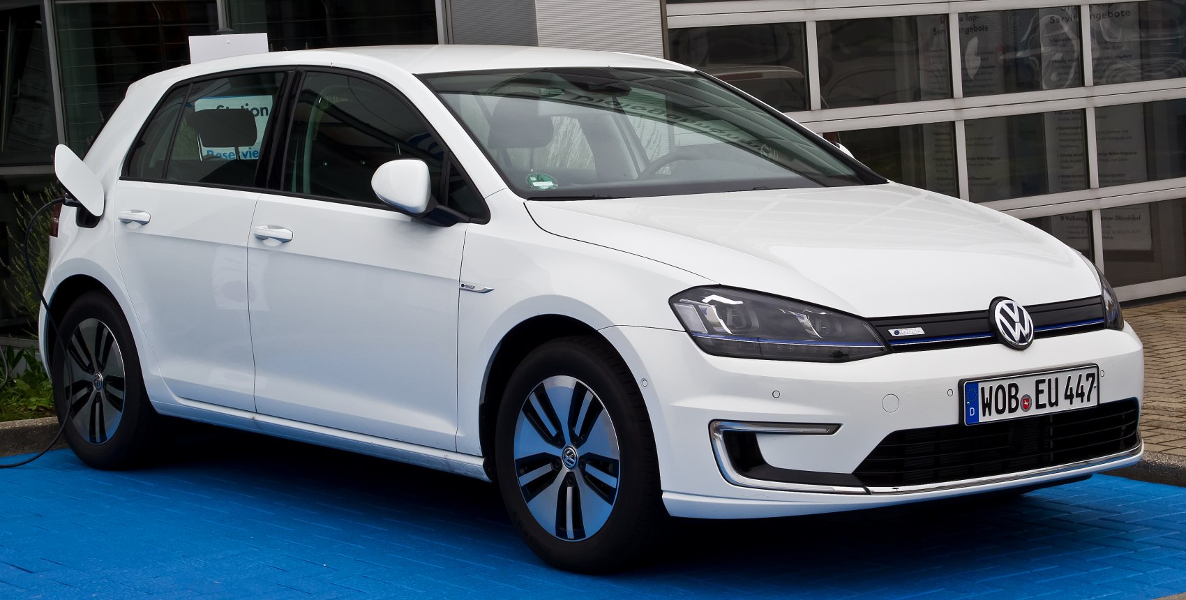 5-door hatchback electric vehicle at charging station, front-side view