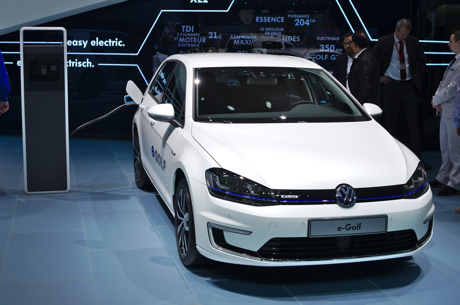 Front view of a white electric hatchback with charging cable connected