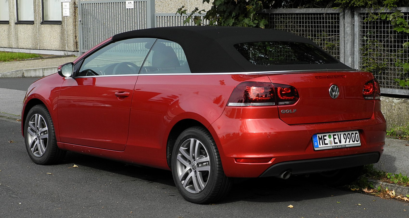 Rear side view of convertible with closed black soft top and alloy wheels