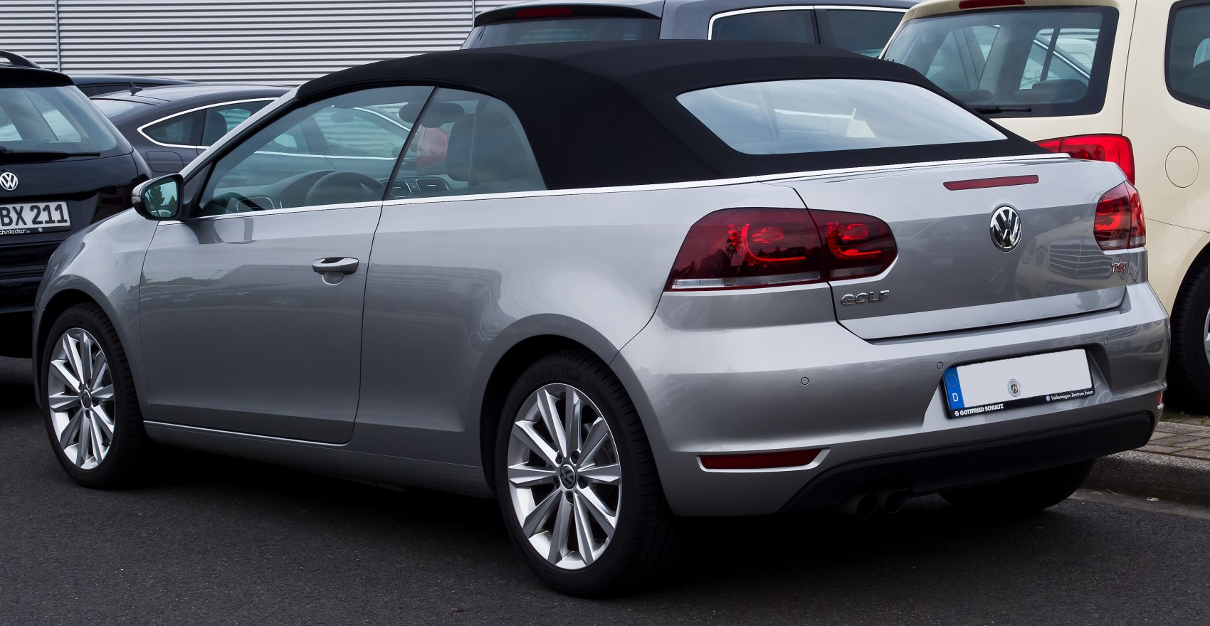 Rear and side view of silver convertible with soft top roof and alloy wheels