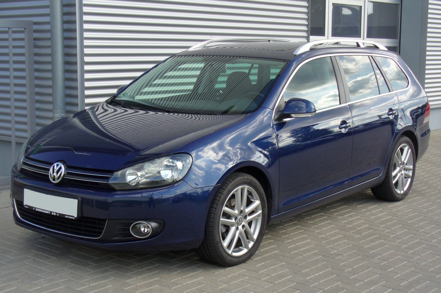 Front side view of a station wagon with alloy wheels and distinctive headlights.