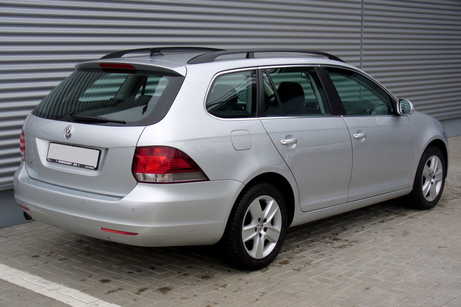 Rear side view of silver station wagon with roof rails and alloy wheels