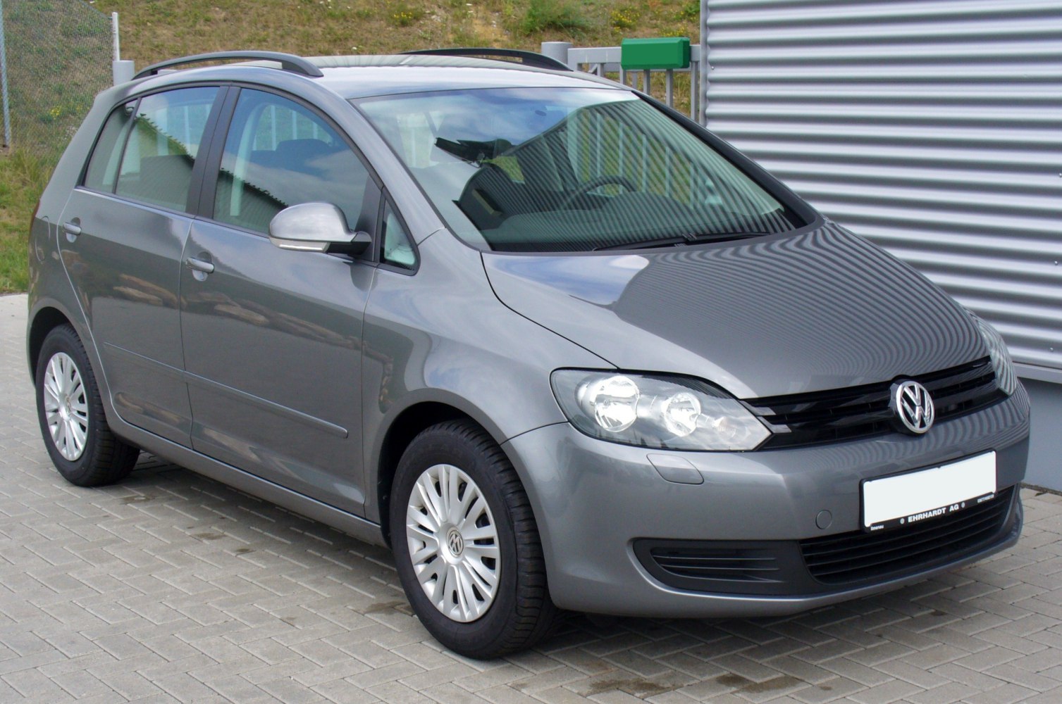 Front side view of hatchback with headlights, grille, and alloy wheels