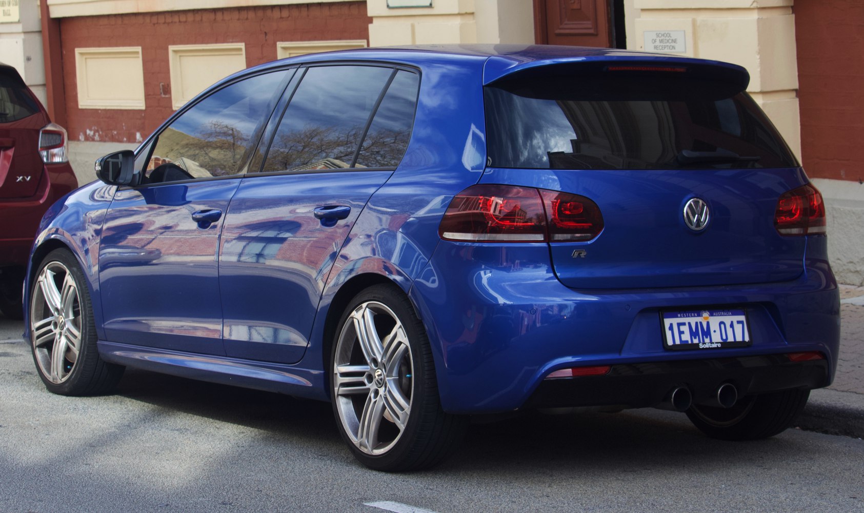 Blue 5-door hatchback rear view with R badge and dual exhaust