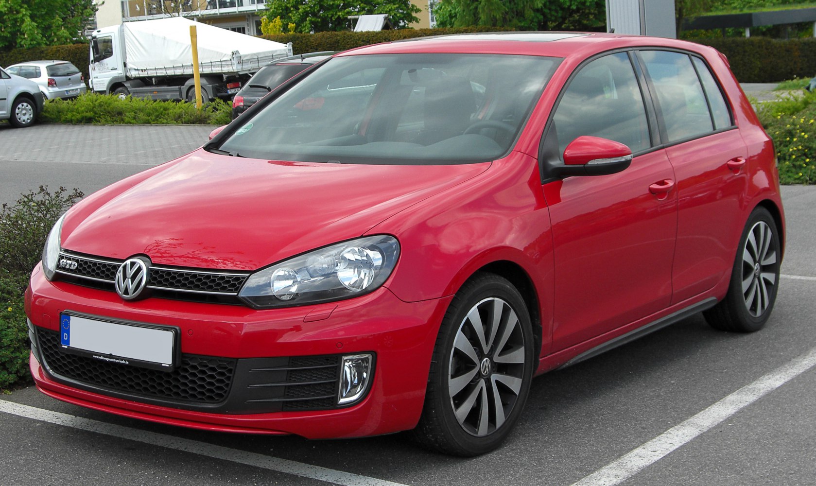 Red five-door hatchback with sleek headlights and alloy wheels