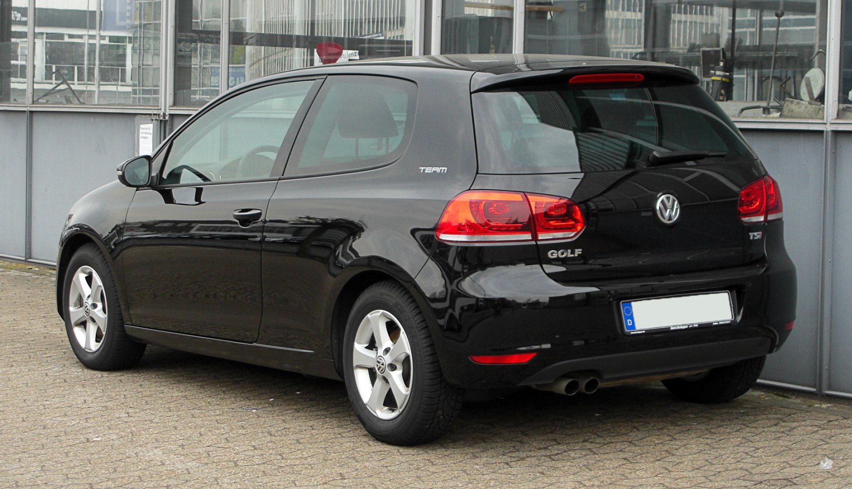 Rear and side view of black 3-door hatchback with distinct tail lights and dual exhaust