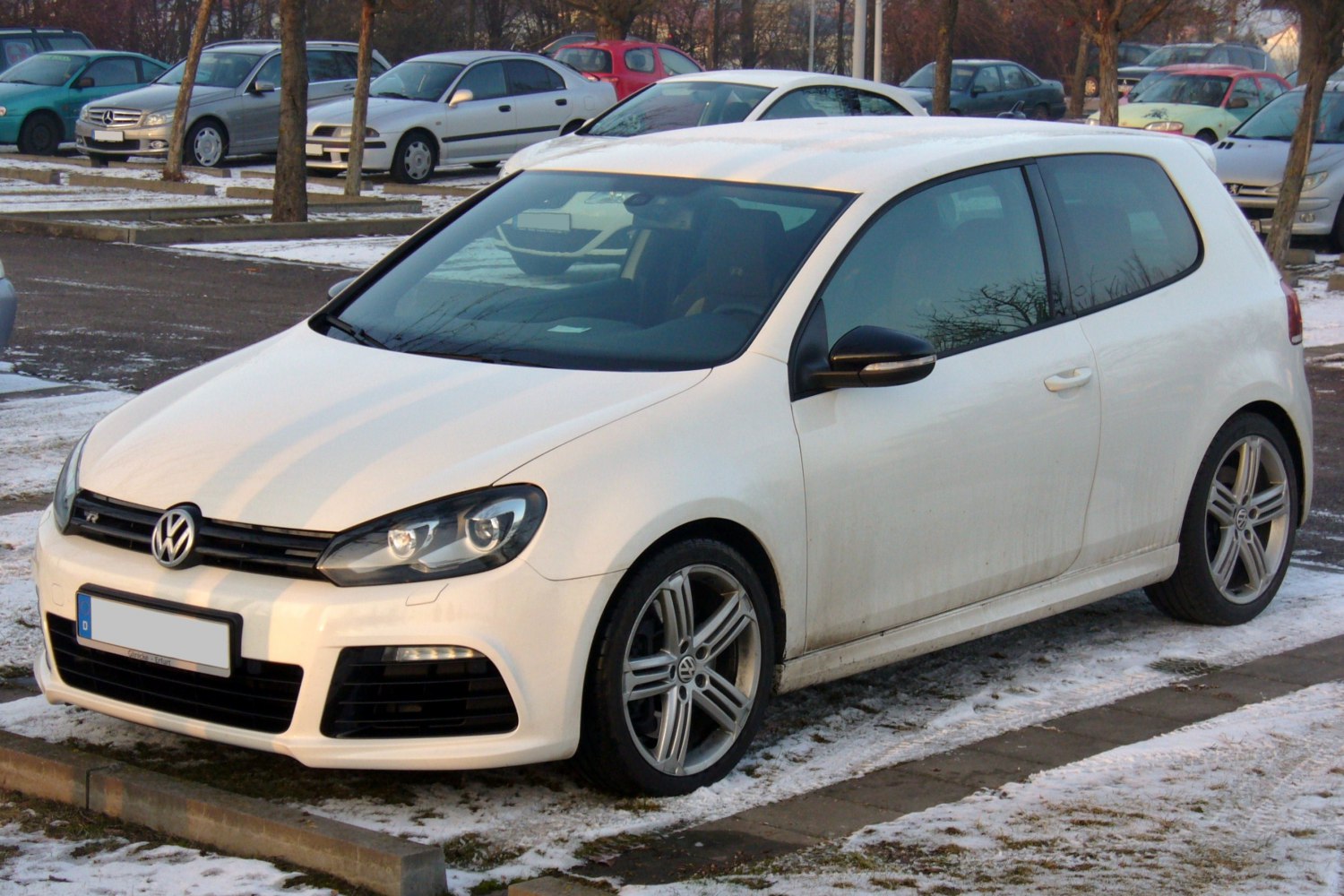 3-door white hatchback front side view with alloy wheels in winter setting