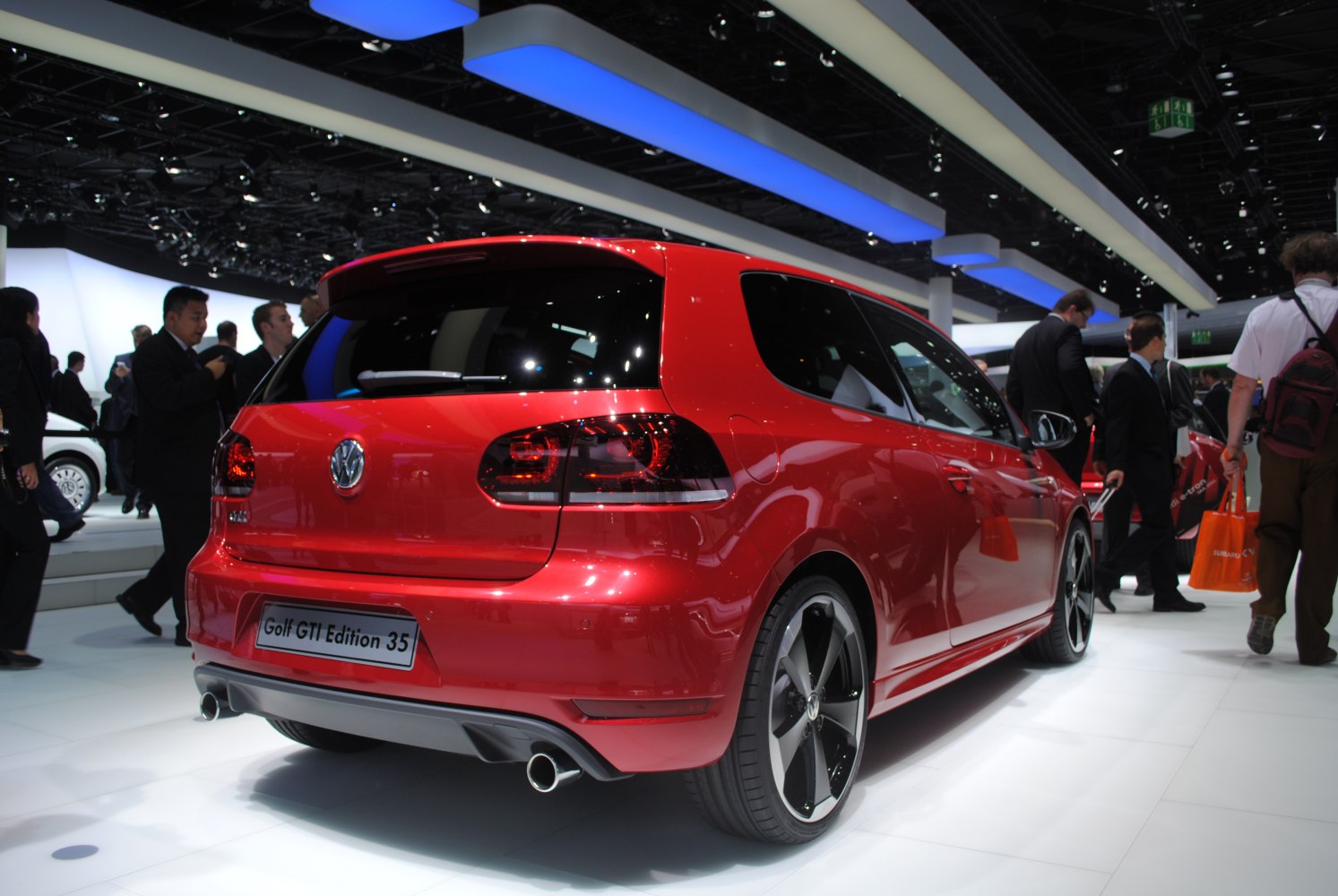 Red 3-door hatchback rear with dark taillights, dual exhaust, sporty wheels