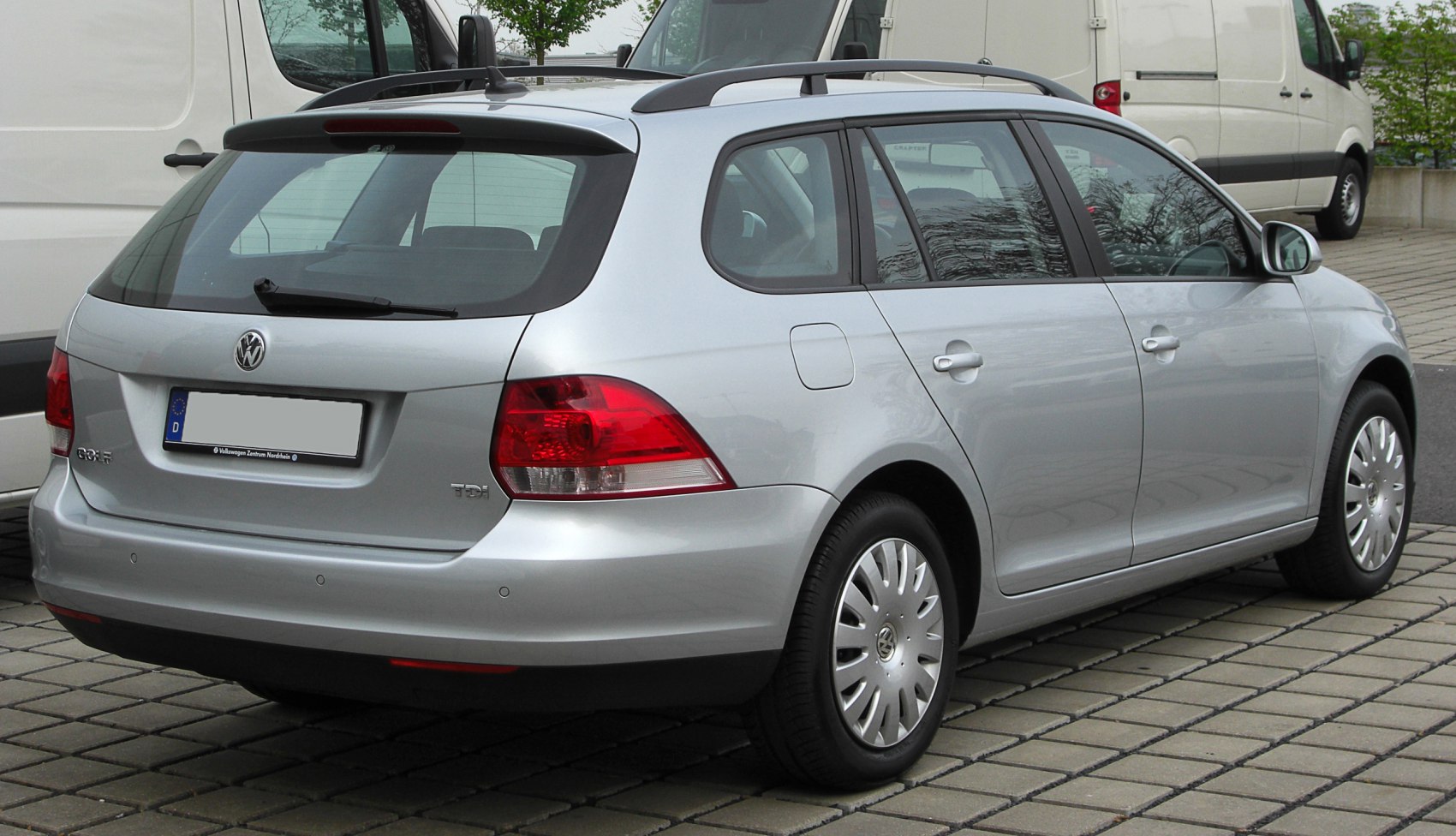 Rear side view showing tail lights, rear wiper, and roof rails