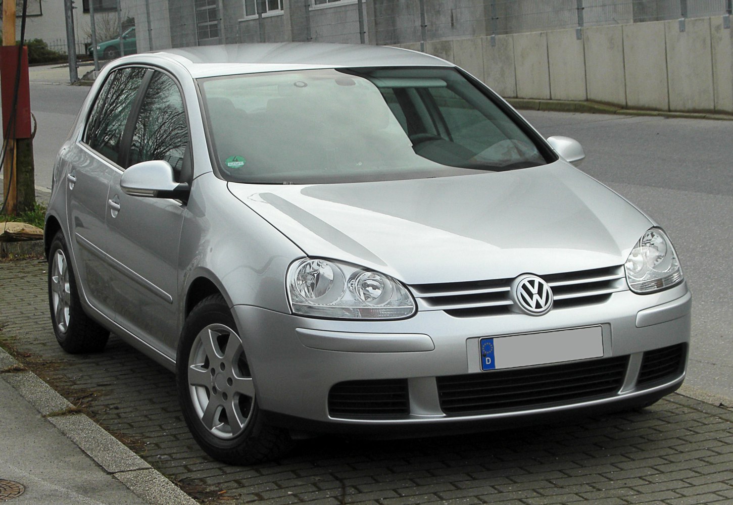 Silver 5-door hatchback with dual round headlights and alloy wheels