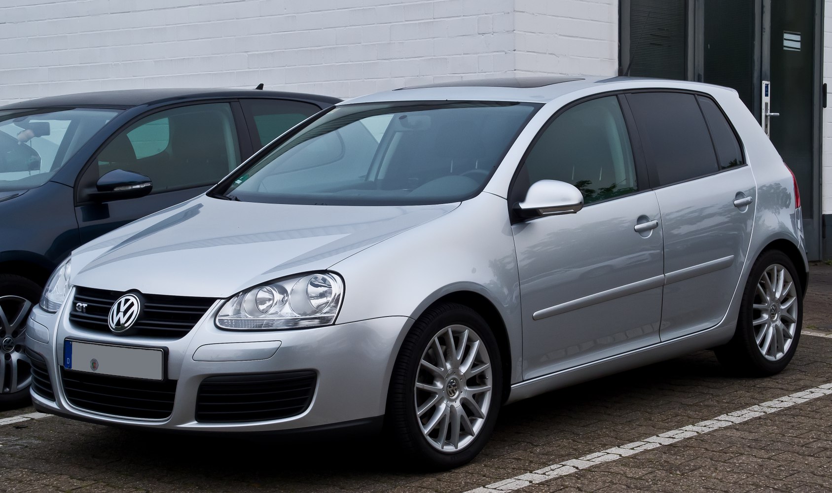 Silver 5-door hatchback front-side view with alloy wheels and defined headlights
