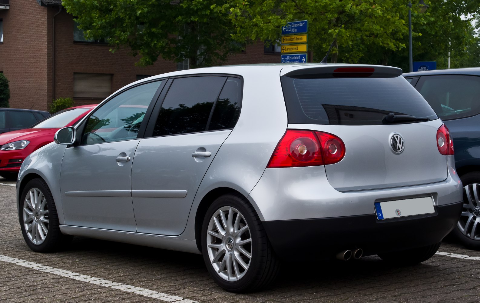 Silver 5-door hatchback rear side with alloy wheels and dual exhaust