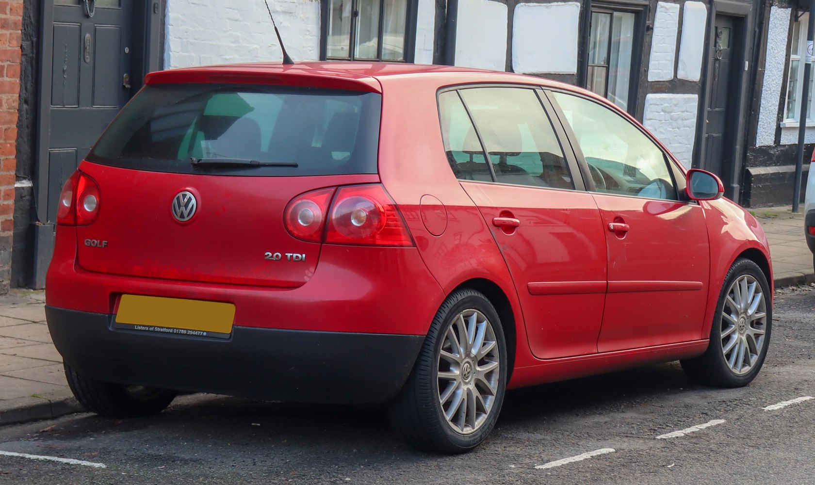 Rear and side view of a red 5-door hatchback with alloy wheels