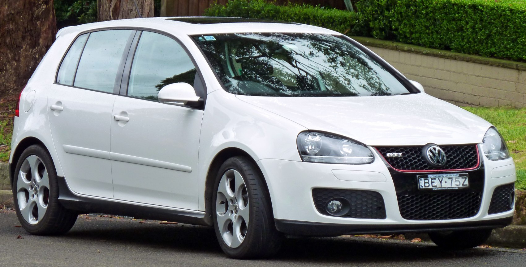 White 5-door hatchback with sporty grille and alloy wheels, front-side view