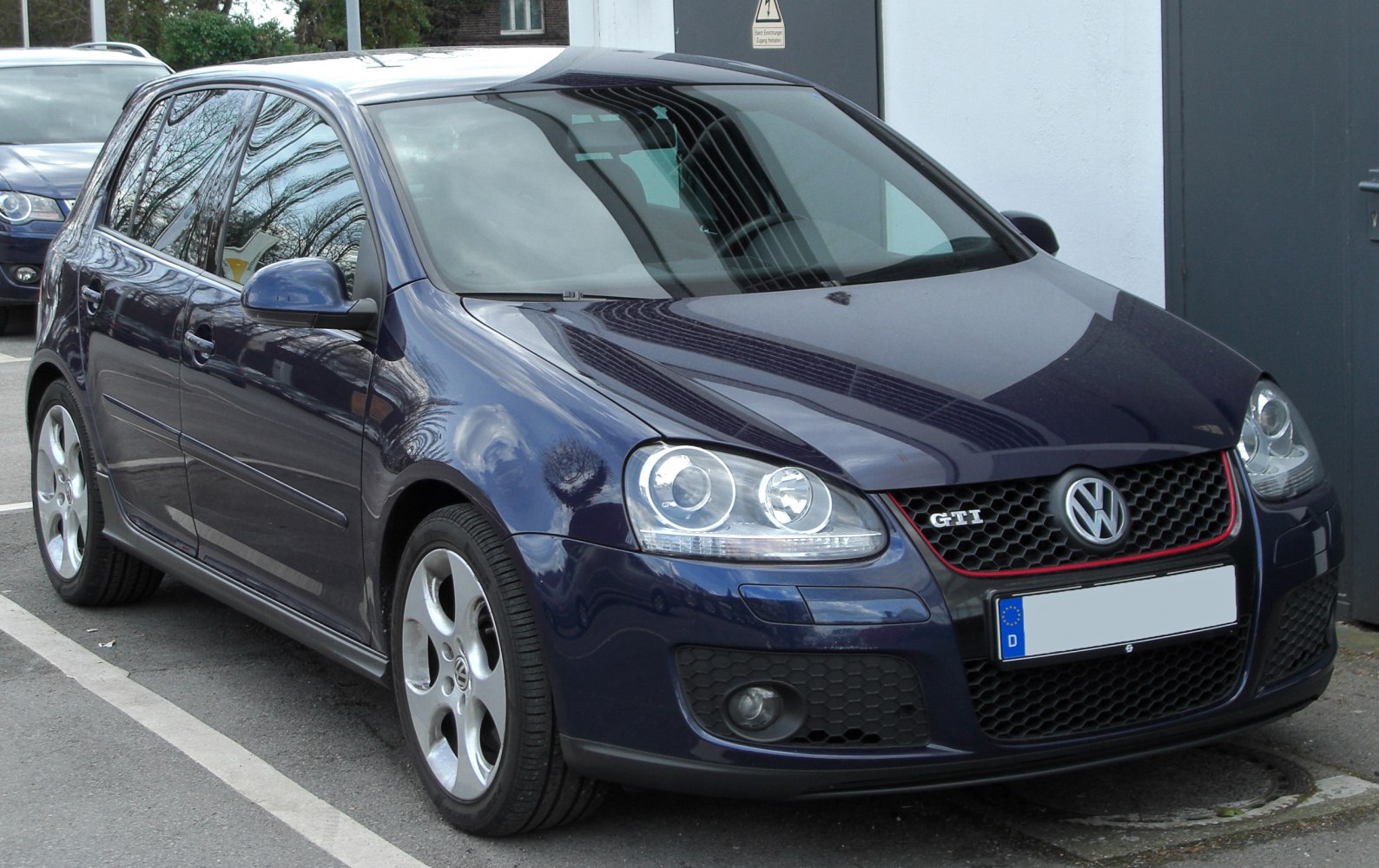 Front view with headlights, honeycomb grille, and sporty rims