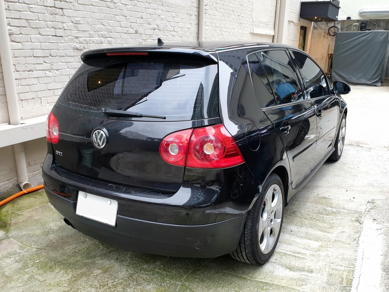Rear of a 5-door hatchback with round red tail lights and alloy wheels