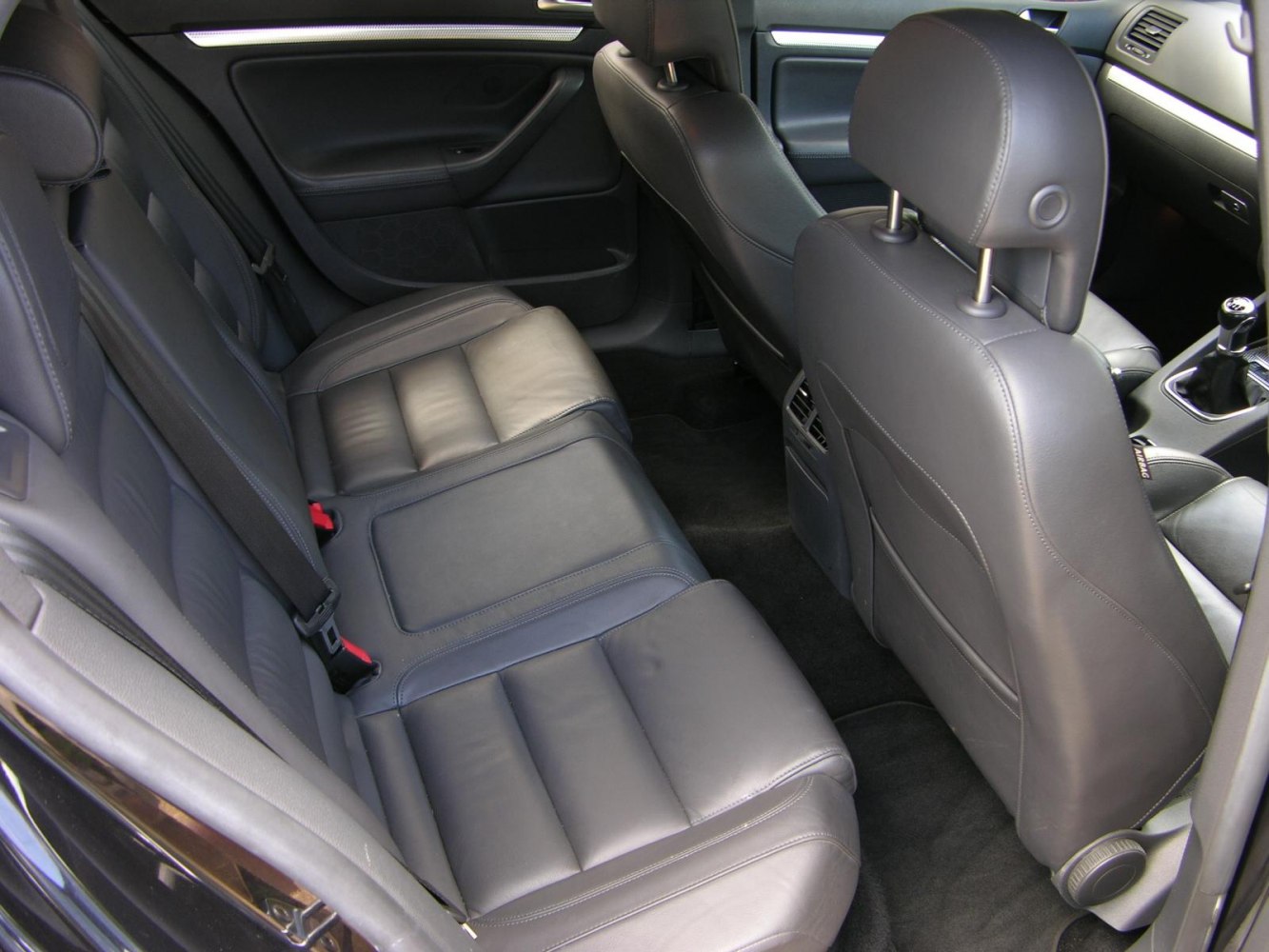 Rear black leather seats and interior space with seat belts