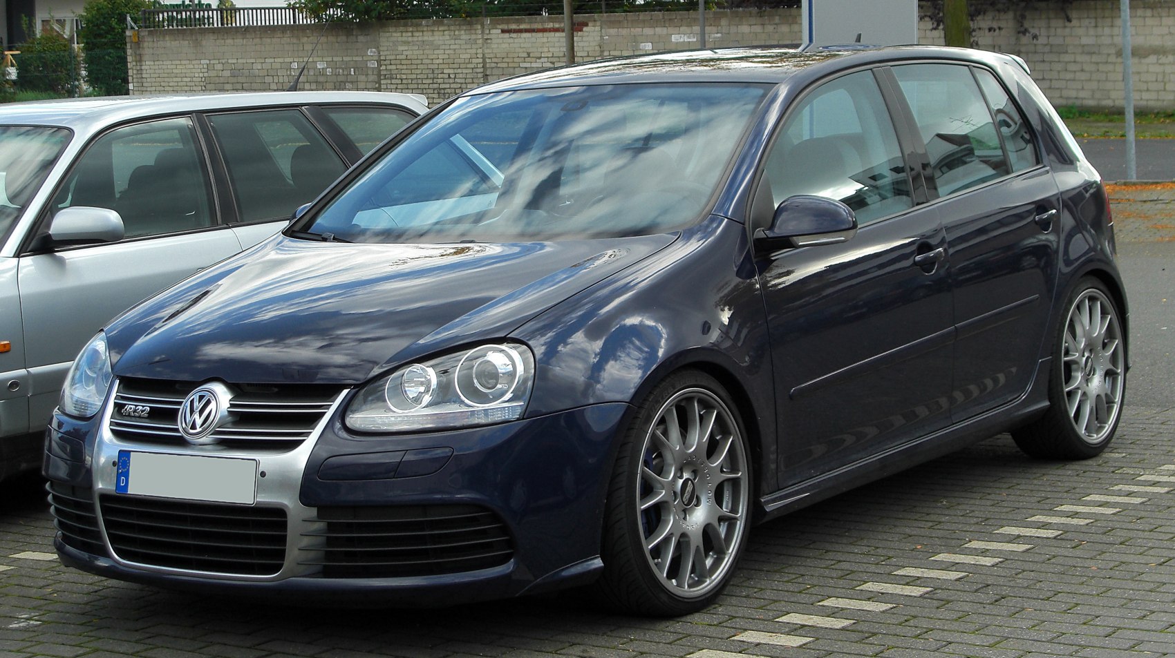 Front side view of 5-door hatchback with alloy wheels and dual headlights