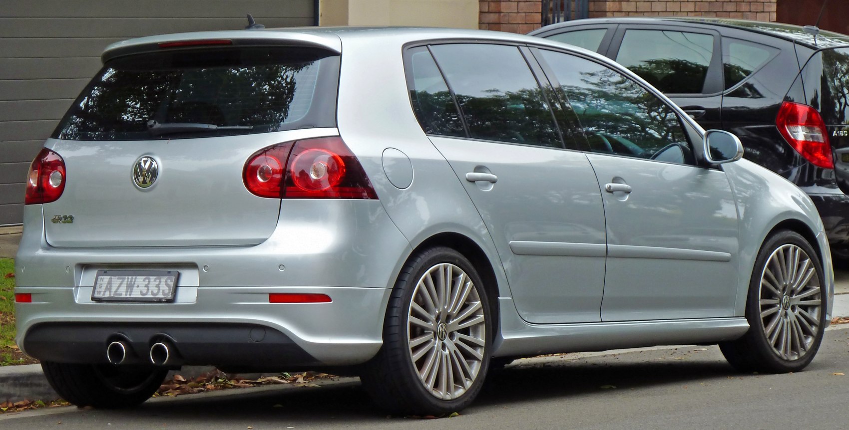 Silver 5-door hatchback rear with dual exhaust and multi-spoke alloy wheels