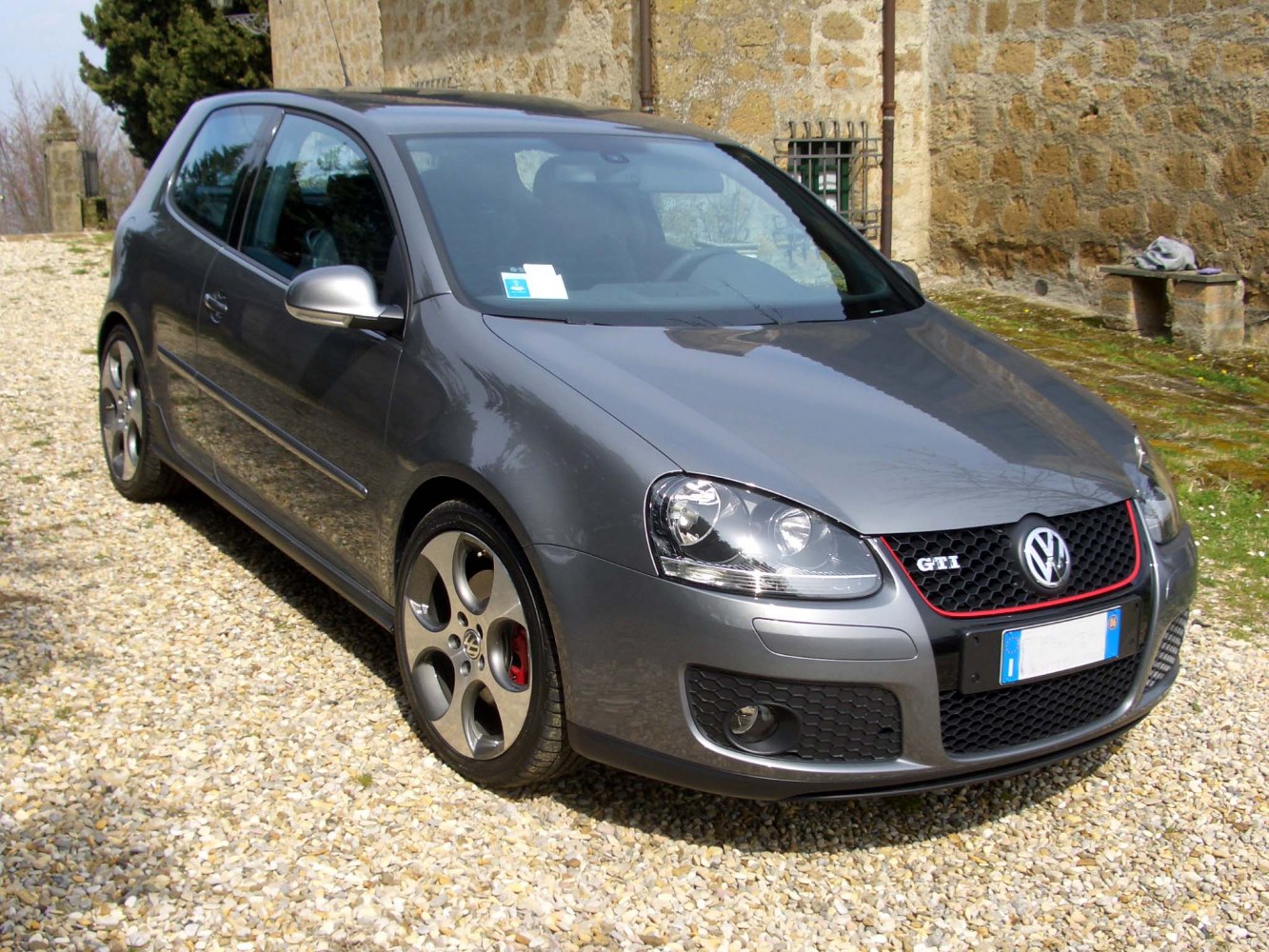 3-door sporty hatchback with red-trimmed grille and five-spoke alloy wheels