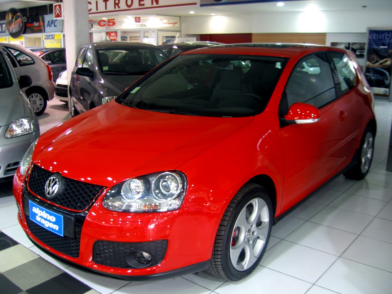 Red hatchback with distinct front grille and alloy wheels