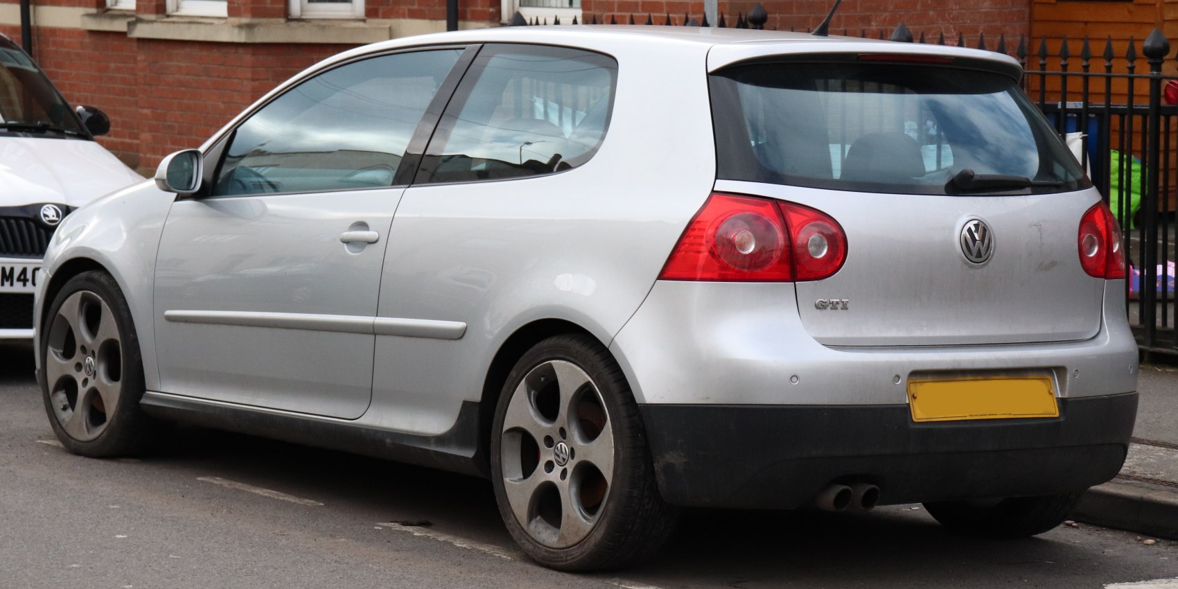 Silver 3-door hatchback rear side with GTI badge and exhaust pipes