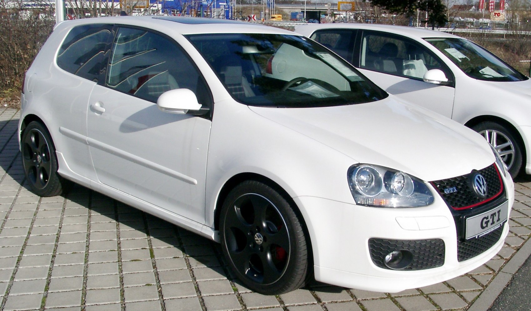 White 3-door hatchback with black wheels and detailed headlights