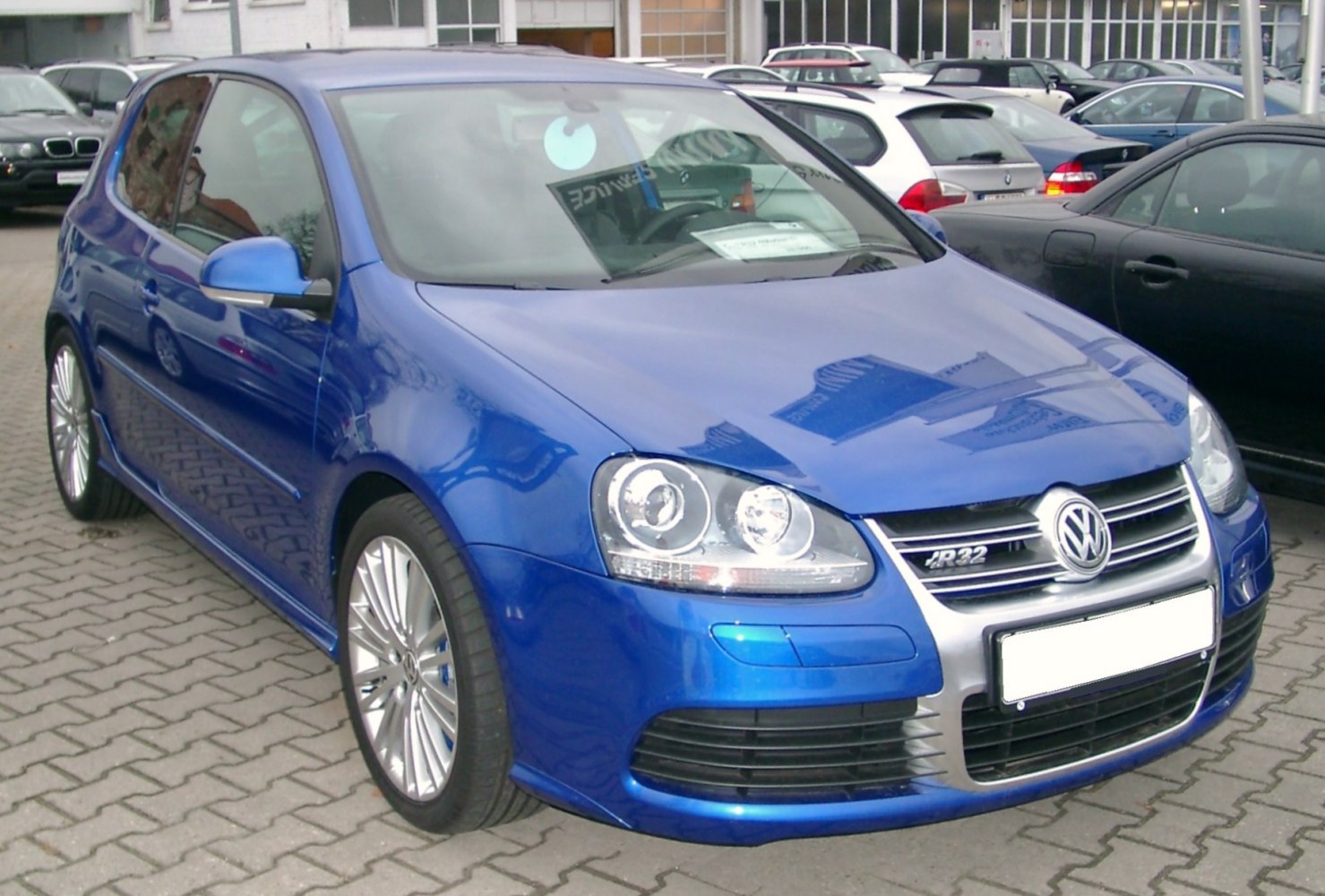 Front-side view showing dual headlights and multi-spoke alloy wheels