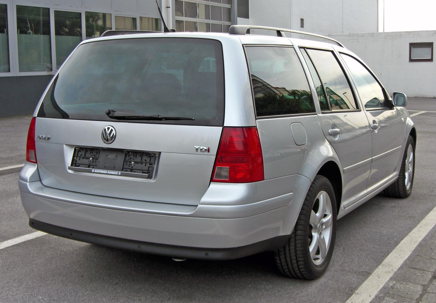 Rear view of a silver estate car with notable tail lights and rear window wiper.