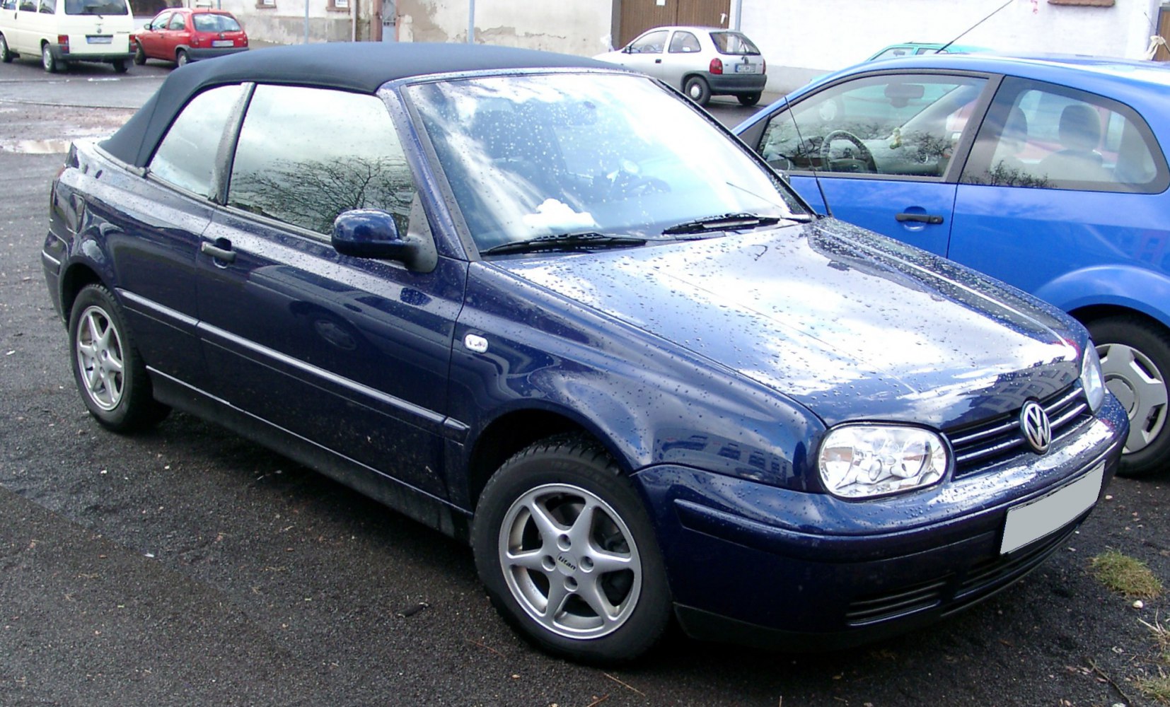 Blue compact convertible with black soft top roof and alloy wheels