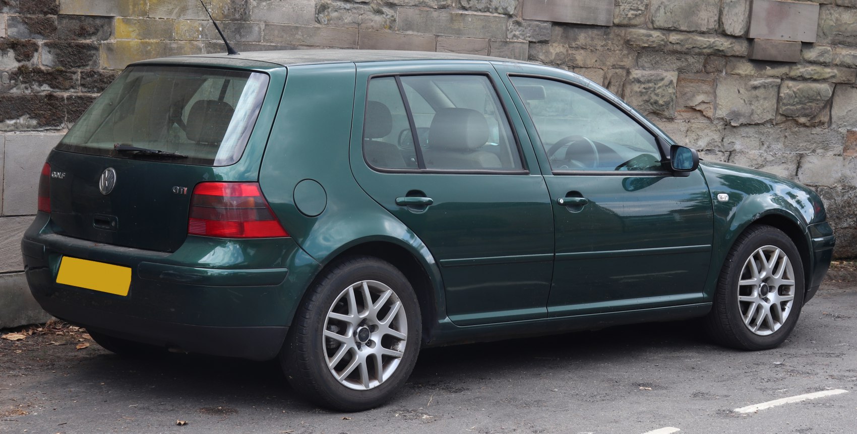 Green 5-door hatchback from side and rear view with alloy wheels