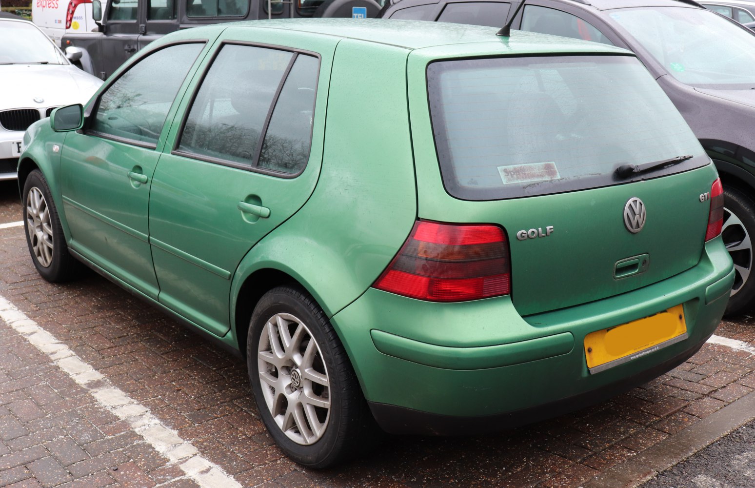Rear three-quarter view of a green hatchback with GTI badge and alloy wheels